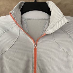 LuluLemon 1/2 zip athletic top size S. Light gray with orange trim.